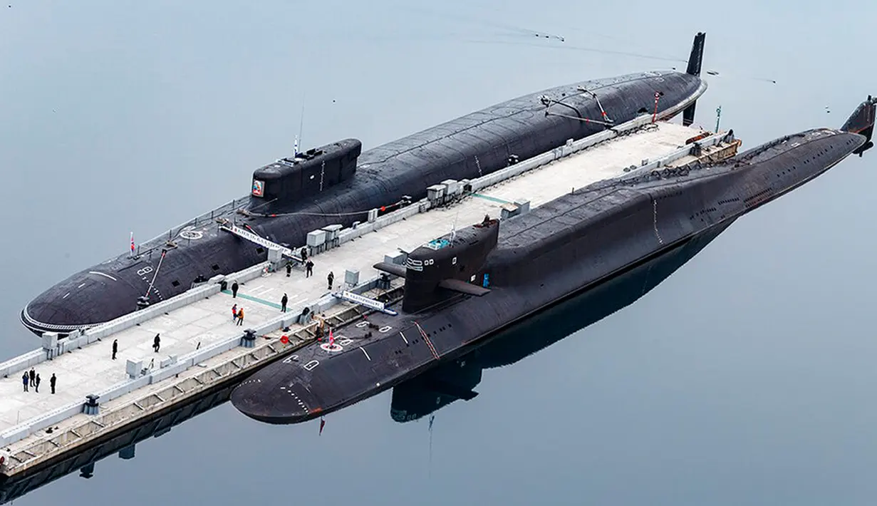 Dalam foto yang dirilis oleh Layanan Pers Kementerian Pertahanan Rusia ini, kapal selam nuklir Rusia Pangeran Vladimir (atas) dan Yekaterinburg berlabuh di pangkalan angkatan laut Rusia di Gazhiyevo, Semenanjung Kola, Rusia, 13 April 2021. Para analis tidak yakin Presiden Rusia Vladimir Putin bersedia menjadi orang pertama yang melepaskan senjata nuklir sejak AS mengebom Jepang pada 1945. (Russian Defense Ministry Press Service via AP, File)