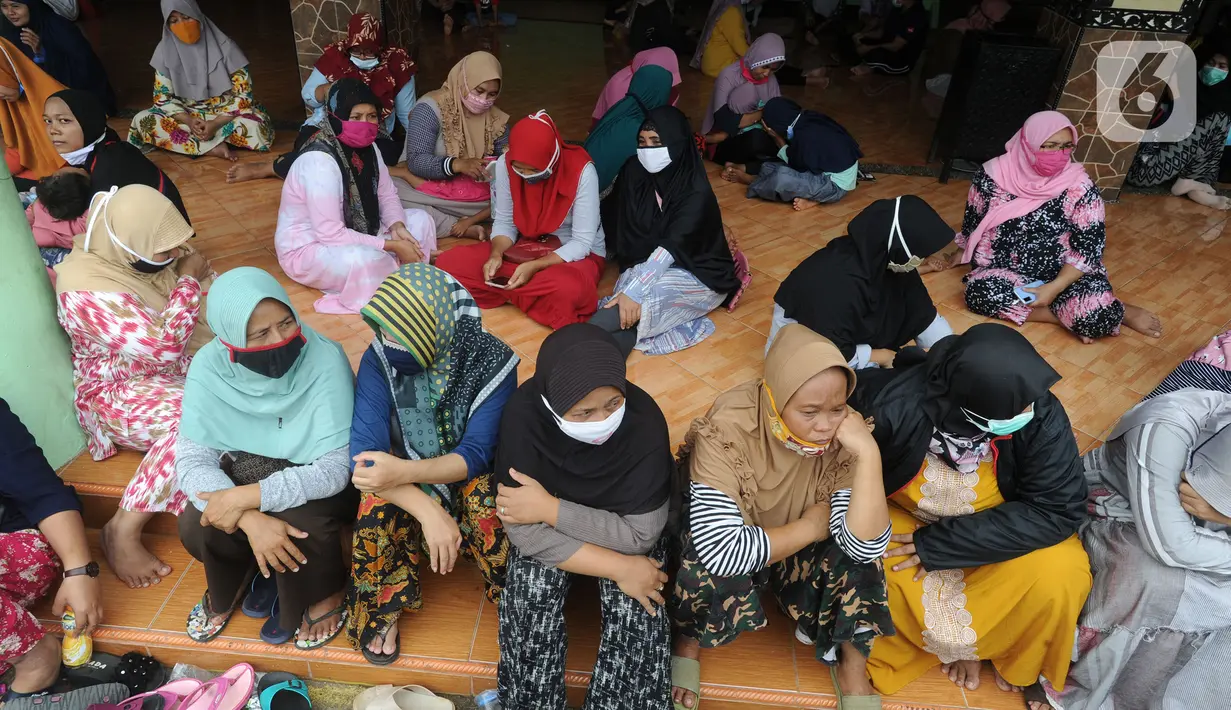 Warga menunggu giliran menerima uang Bantuan Sosial Tunai (BST) bulan Januari di halaman Masjid Jami Al-Hidayah RW 01 Bedahan, Depok, Selasa (16/2/2021). Sekitar 159.470 Keluarga Penerima Manfaat di Kota Depok menerima BST yang disalurkan PT Pos Indonesia pada Februari ini. (merdeka.com/Arie Basuki)
