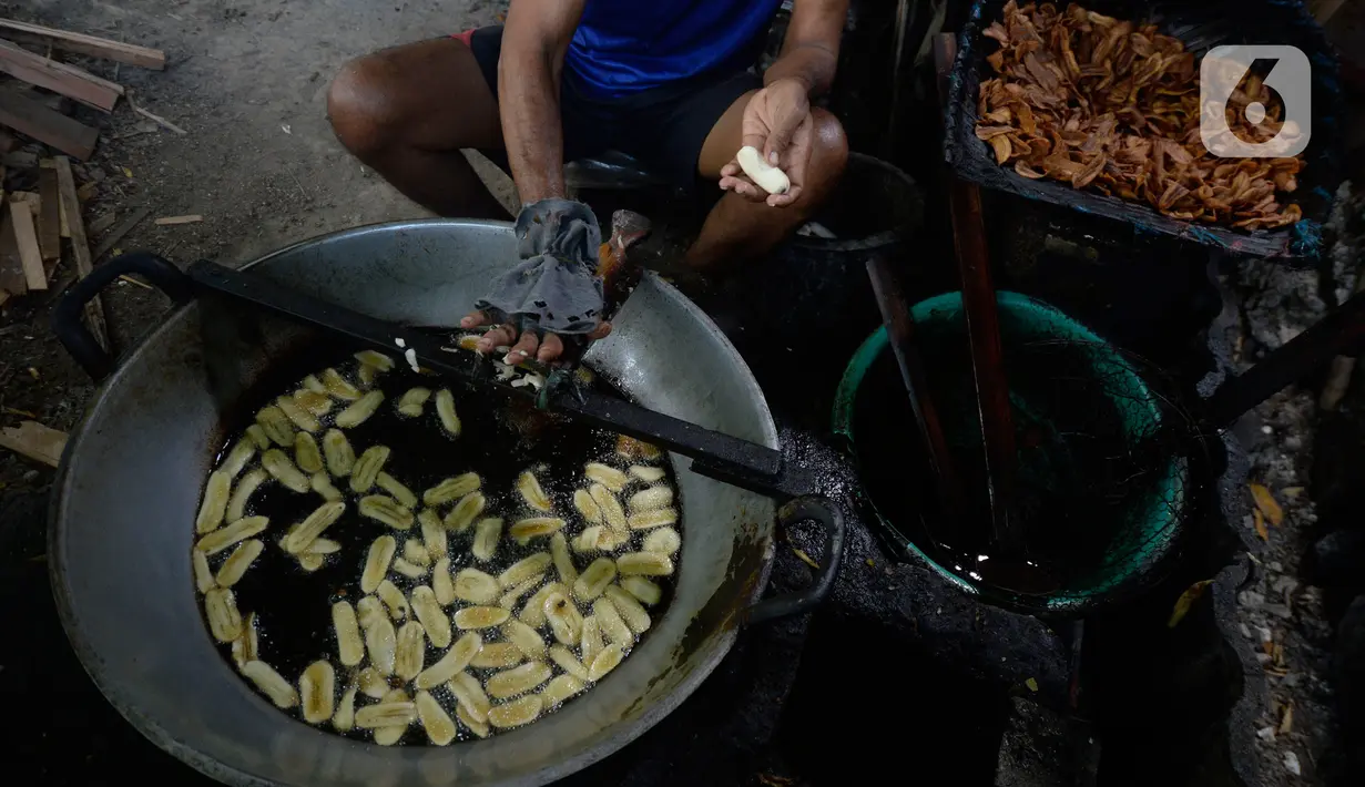Pekerja memotong dan langsung menggoreng pisang untuk dijadikan keripik di Desa Cogreg, Parung Bogor, Jawa Barat, Kamis (3/9/2020). Keripik Pisang tersebut akan dikirim ke pasar dengan harga Rp 35 ribu untuk menambah pilihan oleh-oleh dari Kota Hujan. (merdeka.com/Dwi Narwoko)