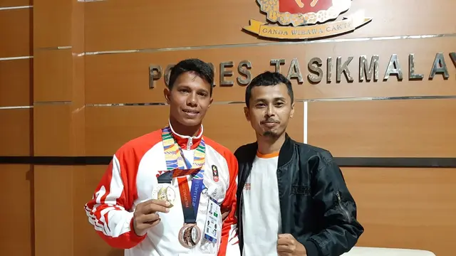 Salah seorang warga Tasikmalaya, tengah berfoto bersama Muhammad Taufik (32), atlet peraih emas cabang triathlon dan modern pentathlon Men's Beach Laser Individual