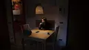 Elisabetta Teti, spesialis penyakit menular berusia 39 tahun, meminum kopinya saat sarapan di ruang tamunya, di Roma, 7 November 2020. Hari kerja dimulai dalam kegelapan, suaminya masih tertidur ketika dia menyelinap keluar dari apartemen mereka ke Rumah Sakit. (AP Photo/Alessandra Tarantino)