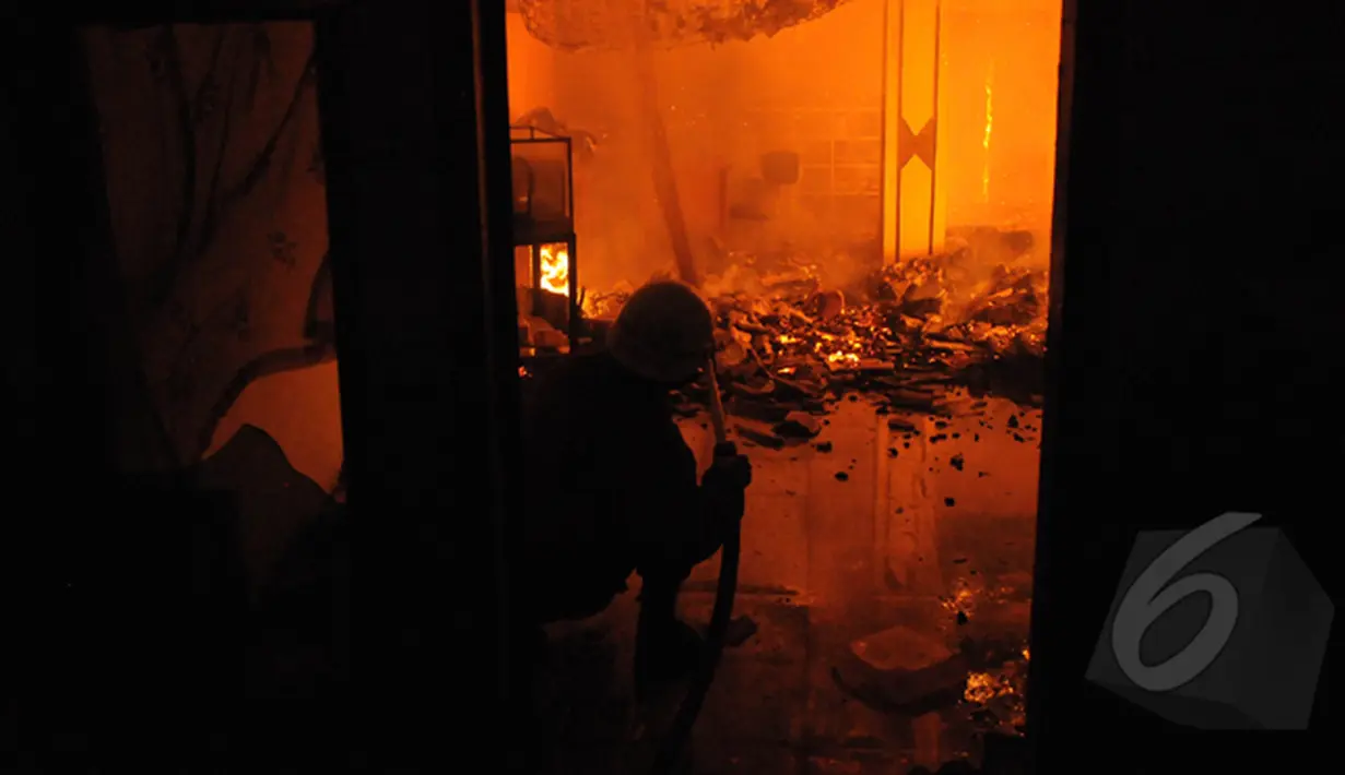 Petugas Damkar menyemprotkan air ke arah rumah warga yang dilalap api di kawasan Tanah Abang, Jakarta, Kamis (5/3/2015). Diperkirakan sekitar 200 rumah warga hangus terbakar.(Liputan6.com/Herman Zakharia)