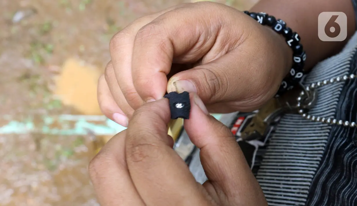 Seorang anak yang tergabung dalam Ketapel Anak Ciliwung (Kancil) saat bermain ketapel di kawasan Ciliwung Muara Baru, Jakarta, Selasa (9/11/2021). Selain melestarikan permainan tradisional, bermain ketapel melatih kesabaran, konsentrasi dan motorik otak kanan anak. (Liputan6.com/Herman Zakharia)