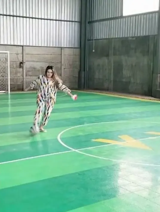 Bukti kecintaannya terhadap sepak bola membuat Via Vallen tidak ragu untuk menendang bola saat berada di lapangan futsal. Gaya penampilan Via Vallen yang memakai piyama sambil menendang bola ini mencuri perhatian karena ia tetap terlihat kece. (Liputan6.com/IG/@viavallen)