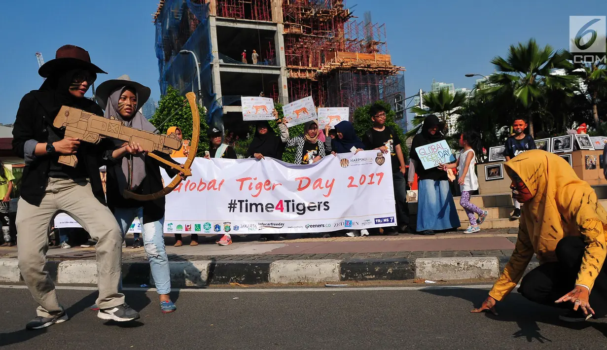 Sejumlah massa yang tergabung dalam forum harimaukita menggelar aksi teatrikal saat mengkampanyekan Global Tiger Day di Bundaran HI, Jakarta, Minggu (30/7). Acara ini untuk memperingati Tiger Day yang jatuh setiap tgl 29 Juli. (Liputan6.com/Helmi Afandi)
