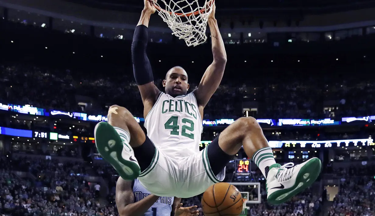 Aksi Pemain Boston Celtics, Al Horford (42) bergelantungan diatas ring usai melakukan dunk saat melawan Memphis Grizzlies, pada lanjutan NBA di TD Garden, (27/12/2016). (AP/Charles Krupa)