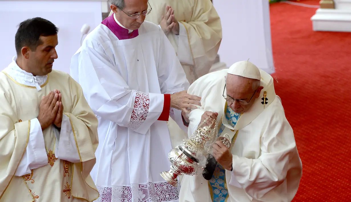 Paus Fransiskus kembali berdiri usai terjatuh saat berjalan di lantai bertingkat menuju altar terbuka di biara Jasna Gora, Polandia, Kamis (28/7). Kunjungan Paus Fransiskus ke Polandia untuk menghadiri perayaan World Youth Day. (FILIPPO MONTEFORTE/AFP)