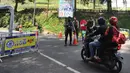 Pengendara motor melawati jalan yan dijaga polisi di di kawasan Puncak, Bogor (29/03). Akibat terjadi longsor di Ciloto, sejumlah jalan di kawasan puncak ditutup. (Merdeka.com/Arie Basuki)