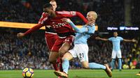 Pemain Watford, Kiko Femenia (kiri) berusaha menahan laju pemain Manchester City, David Silva saat berebut bola pada lanjutan Premier League di Etihad stadium, Manchester, (2/1/2018).  City menang 3-1. (AFP/ Oli Scarff)