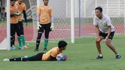 Pelatih kiper Timnas Indonesia U-19, Kim Hae-won, memberikan arahan kepada Cahya Supriadi saat latihan. (Bola.com/M Iqbal Ichsan)