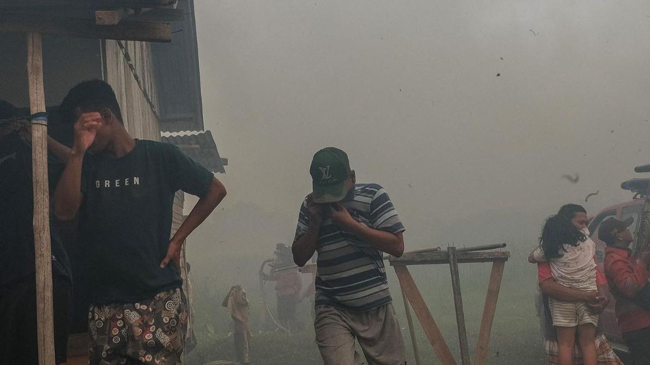 Asap tebal kebakaran hutan dan lahan (karhutla) mengepung sebuah permukiman warga di Ogan Ilir, Sumatera Selatan, pada Rabu (28/9/2023). Kepulan asap itu menyebar ketika api karhutla mulai mendekat ke permukiman mereka.