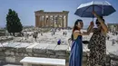 Wisatawan melindungi diri dari matahari saat mengunjungi Acropolis di Athena, Yunani, Minggu (24/7/2022). Negara ini berada dalam cengkeraman gelombang panas yang dimulai pada 23 Juli dan akan berlangsung beberapa hari. Suhu diperkirakan akan mencapai 42 derajat Celcius (107 derajat Fahrenheit) di beberapa daerah.
(Louisa GOULIAMAKI / AFP)