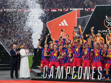 Para pemain Barcelona mengangkat trofi juara Piala Super Spanyol 2026 setelah mengalahkan Real Madrid dengan skor 3-2 dalam laga final yang berlangsung di King Abdullah Stadium, Jeddah, Arab Saudi, Minggu (11/01/2026) waktu setempat. (AP Photo/Altaf Qadri)
