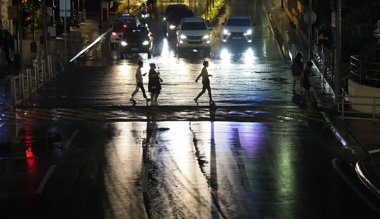 Orang-orang menyeberang jalan di area komersial di kota Quezon, Filipina, Kamis (14/10/2021). Pemerintah Filipina melonggarkan pembatasan setelah penurunan kasus Coronavirus di negara itu. (AP Photo/Aaron Favila)