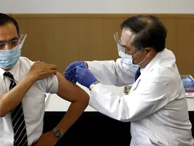 Direktur Pusat Medis Tokyo Kazuhiro Araki (kiri) menerima dosis vaksin virus corona COVID-19 di Tokyo, Jepang, Rabu (17/2/2021). Jepang memulai kampanye vaksinasi COVID-19 dengan suntikan COVID-19 pertama Jepang diberikan kepada petugas kesehatan. (Behrouz Mehri/Pool Photo via AP)