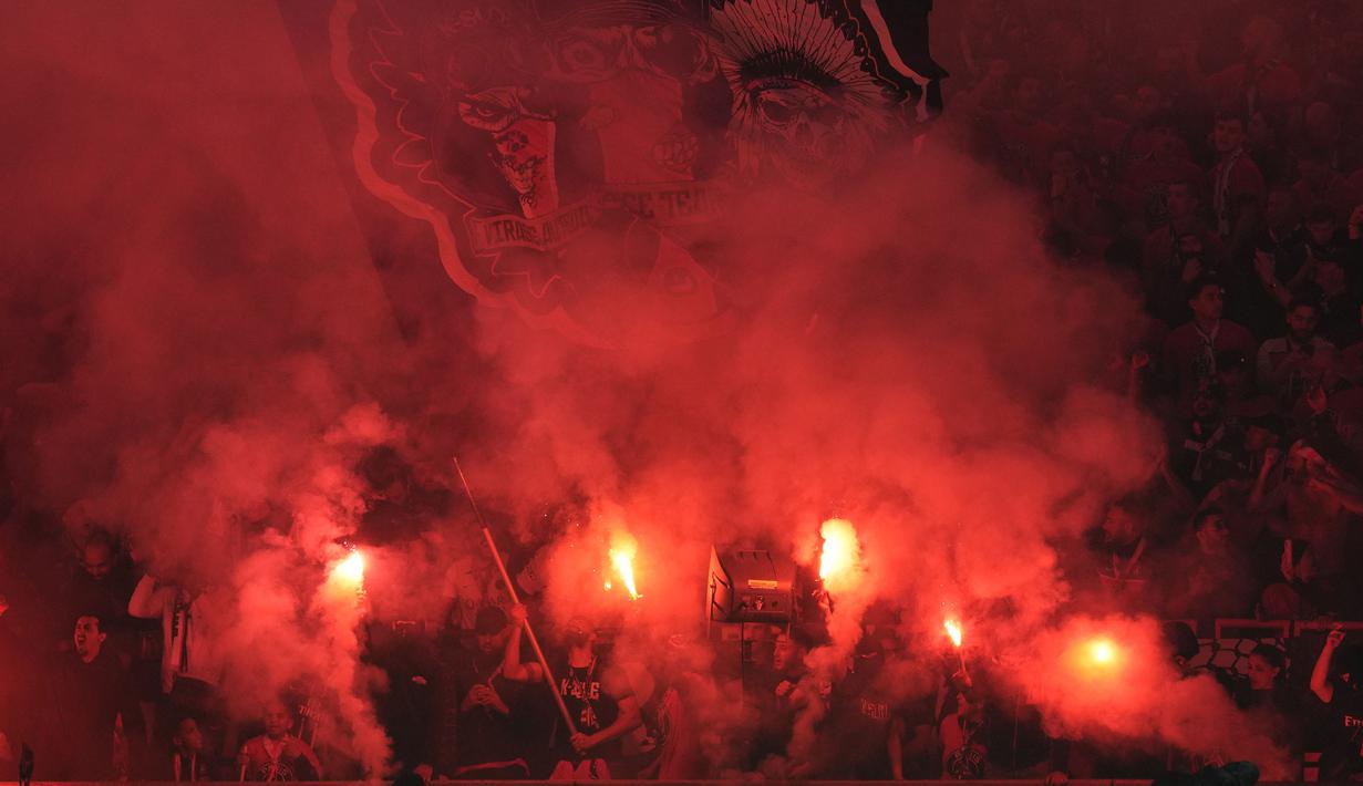 Para pendukung PSG menyalakan suar saat tim kesayangannya menghadapi Borussia Dortmund pada laga leg kedua semifinal Liga Champions 2023/2024 di Parc des Princes Stadium, Paris, Rabu (7/5/2024). (AP Photo/Frank Augstein)