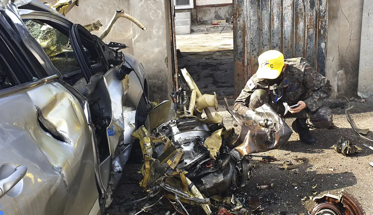 Personel militer memeriksa puing-puing dari tabrakan pesawat latih KT-1 Angkatan Udara Korea Selatan di sebuah desa di Sacheon, Korea Selatan, Jumat (1/4/2022). Dua pesawat angkatan udara Korea Selatan bertabrakan di udara selama pelatihan. (Kim Dong-min/Yonhap via AP)