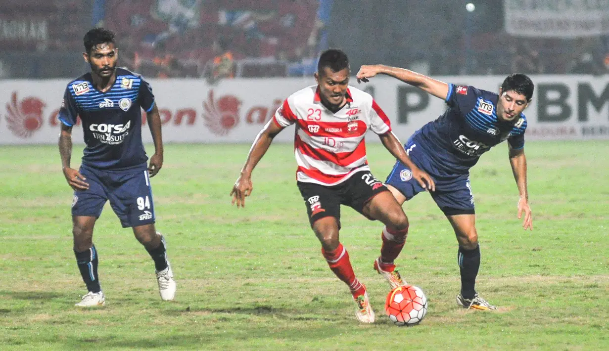 Pemain Arema Cronus, Esteban Vizcara (kanan) dihadang pemain Madura United, Gilang Ginarsa pada laga Torabika Soccer Champions 2016 di Stadion Gelora Bangkalan, Jumat (6/5/2016) WIB. (Bola.com/Iwan Setiawan)