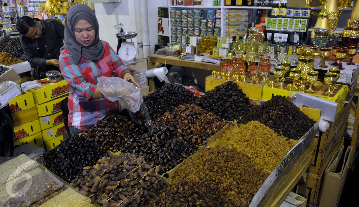 Pedagang mengambil sejumlah kurma yang akan ditimbang di pasar Tanah Abang, Jakarta, Jumat (26/6/2015). Memasuki Ramadan, penjualan kurma meningkat karena buah asal Timur Tengah ini banyak dikonsumsi untuk berbuka puasa. (Liputan6.com/Johan Tallo) 