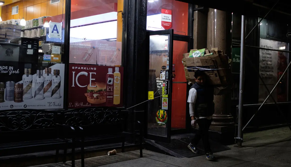 Pekerja membersihkan kotak yang rusak saat menutup toko makanan di New York, Senin (16/3/2020). Bioskop dan kasino hingga pusat kebugaran dan sekitarnya juga akan ditutup pada Senin malam di seluruh New York, New Jersey dan Connecticut. (AP Photo/Yuki Iwamura)