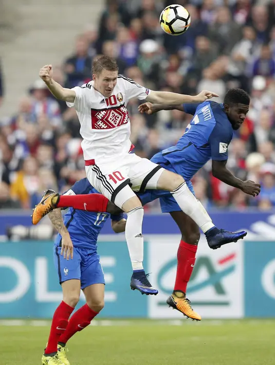 Duel pemain Prancis, Samuel Umtiti (kanan) melawan pemain Belarusia, Anton Saroka pada kualifikasi Piala Dunia 2018 grup A di Stade de France stadium, Saint-Denis (10/10/2017). Prancis menang 2-1. (AP/Christophe Ena)