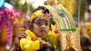 Umat Hindu membawa kanopi berhias yang disebut "kavadi" dan anak-anak berjalan menuju Kuil Swamy Sri Subramaniar pada perayaan Thaipusam di Batu Caves, Kuala Lumpur, Malaysia, Minggu (5/2/2023). Thaipusam, yang dirayakan untuk menghormati Dewa Murugan, adalah acara tahunan umat Hindu untuk mencari berkah, memenuhi sumpah, dan mengucapkan terima kasih. (AP Photo/Vincent Thian)