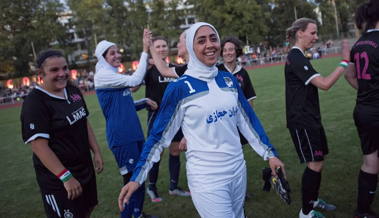 Pesepakbola wanita Iran berjabat tangan dengan pemain wanita Jerman usai pertandingan Discover Football tournament di Berlin, Jerman (31/8). Pesepakbola wanita Iran tampak antusias dengan turnamen ini. (REUTERS/Stefanie Loos)