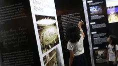 Dua orang anak melihat-lihat dokumentasi pembangunan kompleks olahraga Gelora Bung Karno yang dipamerkan di area Stadion GBK, Jakarta, Rabu (29/8). Sejumlah dokumentasi pembangunan stadion dicetak dan bisa dilihat warga. (Liputan6.com/Helmi Fithriansyah)