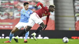 Pemain Manchester City Joao Cancelo (kiri) mencoba menghentikan pemain Manchester United Paul Pogba pada pertandingan semifinal Piala Liga Inggris di Old Trafford, Manchester, Inggris, Rabu (6/1/2021). Manchester City mengalahkan Manchester United 2-0. (Peter Powell/Pool via AP)