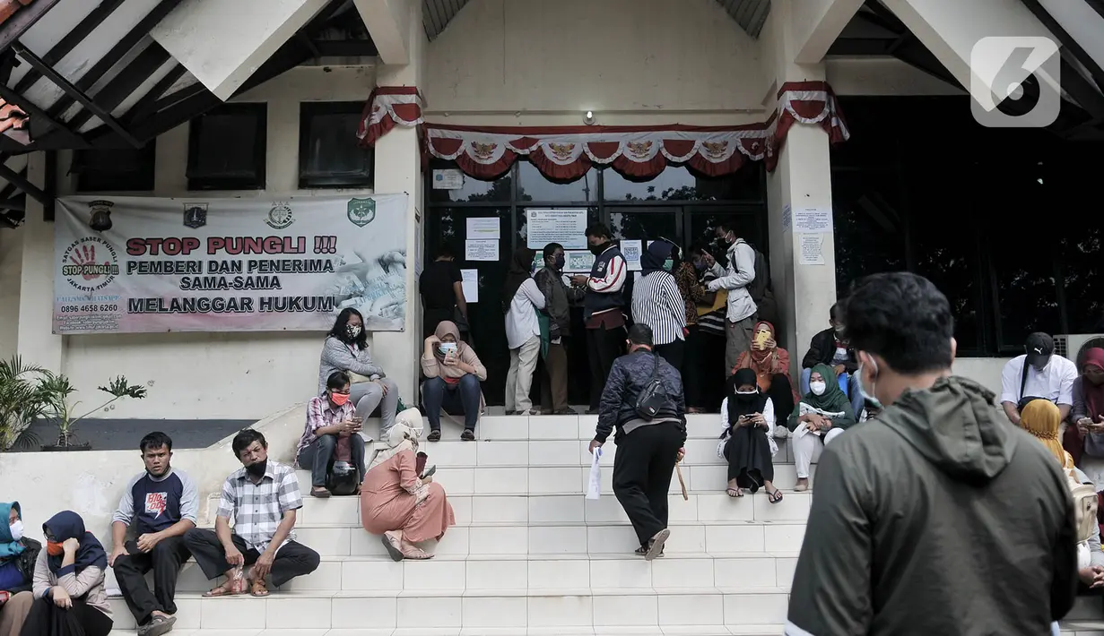 Warga saat antre layanan Kependudukan dan Catatan Sipil di Kantor Suku Dinas Dukcapil Jakarta Timur, Senin (15/6/2020). Layanan tatap muka Dukcapil Jaktim yang dibuka sejak Jumat (12/6) lalu disambut antusias warga yang ingin mengurus dokumen administrasi kependudukan. (merdeka.com/ Iqbal S Nugroho)
