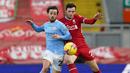 Gelandang Manchester City, Bernardo Silva (kiri) berebut bola dengan bek Liverpool, Andrew Robertson dalam laga lanjutan Liga Inggris 2020/21 pekan ke-23 di Anfield Stadium, Minggu (7/2/2021). Manchester City menang 4-1 atas Liverpool. (AFP/Jon Super/Pool)