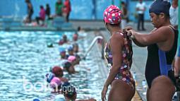 Seorang atlet Polo Air Putri membetulkan baju renang rekannya saat seleksi Nasional di GOR Pertamina Simprug, Jakarta Selatan, Kamis (19/1/2017). Para atlet ini berasal dari DKI Jakarta, Jawa Barat dan 6 kota lainya. (Bola.com/Nicklas Hanoatubun)