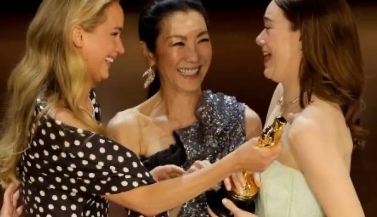 Penyerahan Piala Oscar kepada Emma Stone oleh Michelle Yeoh dan Jennifer Lawrence. [Foto: Instagram/michelleyeoh_official]