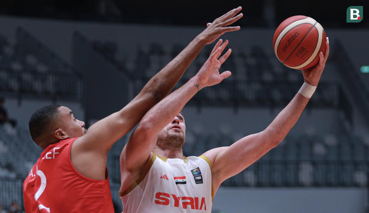 Pemain Timnas Basket Suriah, Emilano Basabe (kanan) berusaha mencetak poin dijaga pemain Timnas Basket Uni Emirat Arab, Ahmed Abdullateef Albreiki pada laga hari pertama Indonesia International Basketball Invitational 2023 melawan Suriah di Indonesia Arena, Senayan, Jakarta, Rabu (02/08/2023). Laga dimenangankan oleh UEA dengan skor 63-61. (Bola.com/Bagaskara Lazuardi)