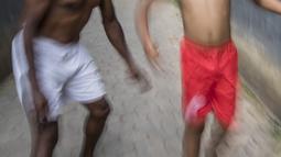 Pesepak bola legendaris, Alexander Pulalo, mengajak anaknya bermain bola saat berada di rumahnya di Sawangan, Jawa Barat, Jumat (13/7/2018). Pemain kelahiran Papua ini merupakan mantan anggota PSSI Primavera. (Bola.com/Vitalis Yogi Trisna)