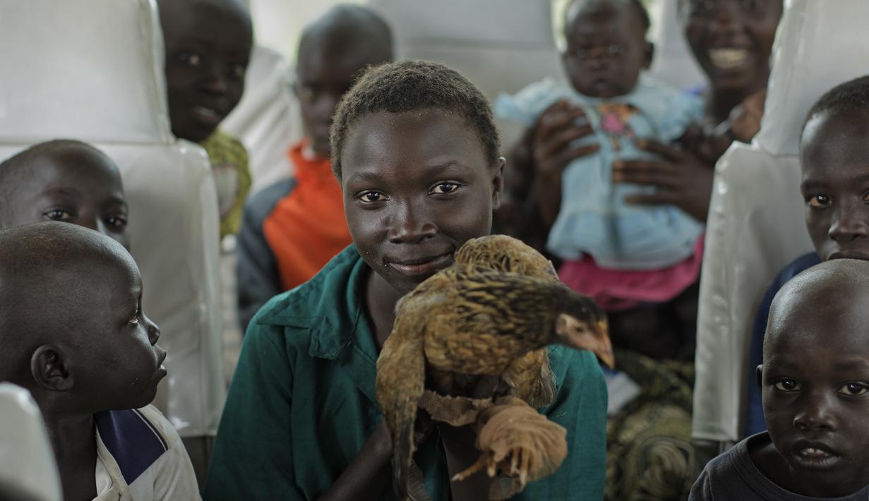 Sejumlah anak Sudan Selatan berada di dalam bus yang akan membawa mereka ke pusat transit pengungsi di Kuluba, Uganda utara, Kamis (8/6). (AP Photo / Ben Curtis)
