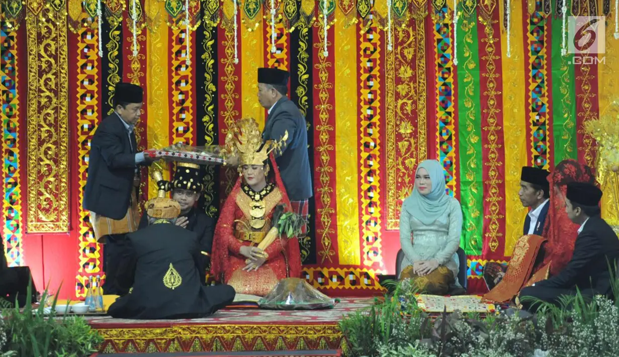 Presiden Joko Widodo dan Ibu Negara Iriana menyaksikan penyerahan upa-upa pada pesta adat Kahiyang Ayu dan Bobby Nasution di  Bukit Hijau Regency Taman Setia Budi (BHR Tasbi), Medan, Sabtu (25/11). (Liputan6.com/Pool/Media Center)