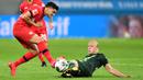 Gelandang Wolfsburg,  Xaver Schlager, berebut bola dengan gelandang Bayer Leverkusen, Nadiem Amiri, pada laga pekan ke-28 Bundesliga di Stadion Bay Arena, Selasa (26/5/2020) waktu setempat. Wolfsburg menang 4-1 atas Bayer Leverkusen. (AFP/Marius Becker/POOL)