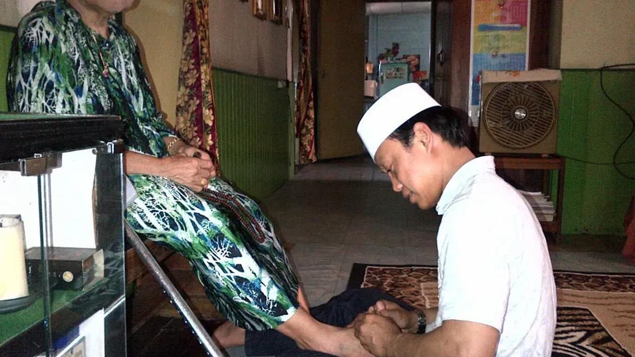 Pijati Kaki Sang Ibu Sembari Duduk di Lantai
