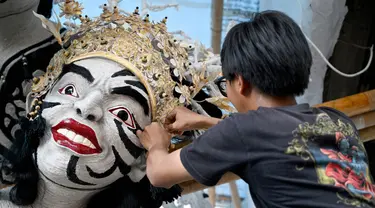 Seorang seniman Bali membuat patung yang disebut "Ogoh-Ogoh" selama persiapan parade tradisional menjelang Hari Raya Nyepi, di Denpasar, Bali, pada tanggal 16 Februari 2024. (SONNY TUMBELAKA/AFP)