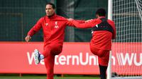 Bek Liverpool, Virgil van Dijk (kiri) melakukan pemanasan selama mengikuti sesi latihan tim di Melwood di Liverpool, Inggris barat laut (22/10/2019). Liverpool akan bertanding melawan wakil Belgia, Genk pada Grup E Liga Champions di Luminus Arena. (AFP/Paul Ellis)