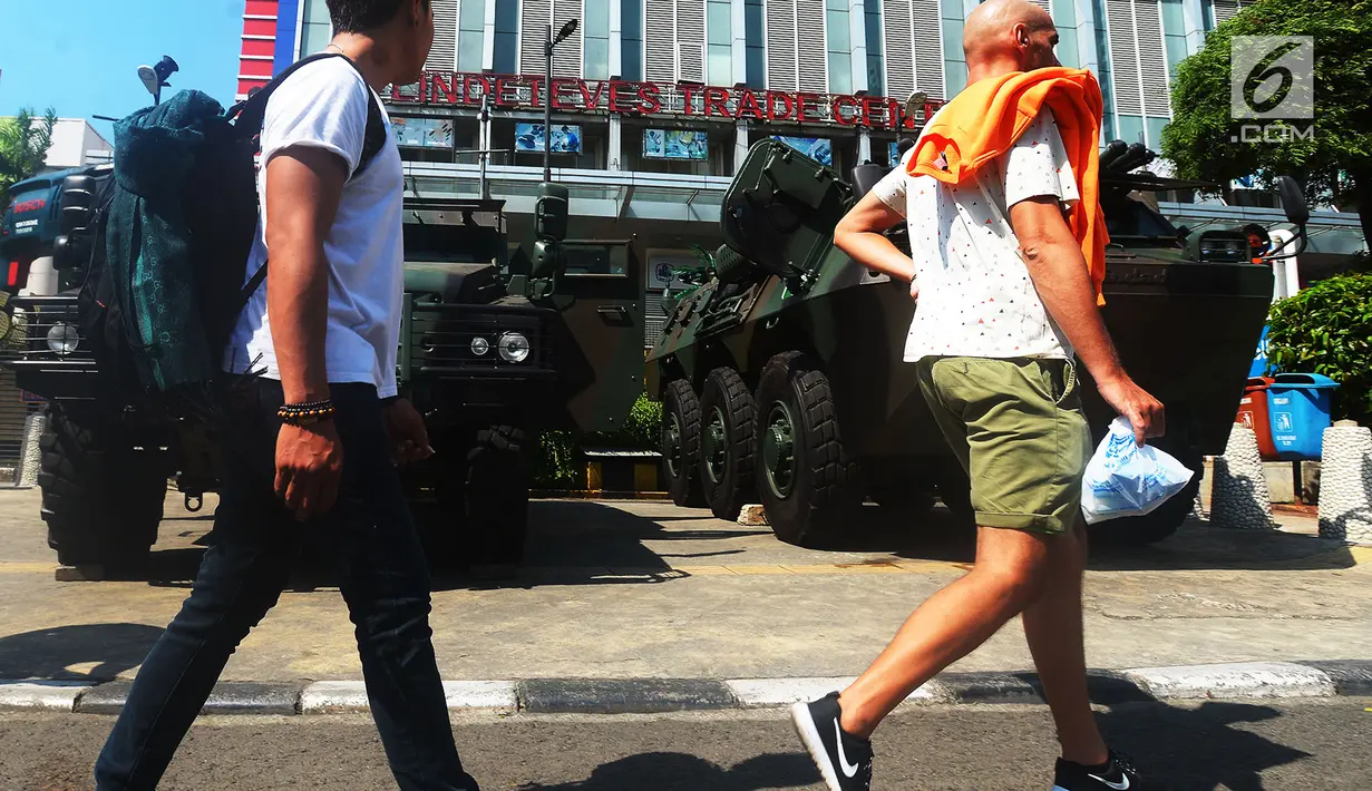 Pejalan kaki melintas di depan kendaraan lapis baja TNI di pertokoan Glodok, Jakarta, Jumat (11/5). Aksi Bela Palestina tersebut sebagai protes atas pemindahan Kedubes AS dari Tel Aviv di Israel ke kota Yerusalem di Palestina. (Merdeka.com/Imam Buhori)