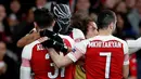 Striker Arsenal Pierre-Emerick Aubameyang mengenakan topeng superhero Black Panther memeluk rekannya usai mencetak gol ke gawang Stade Rennes pada leg kedua babak 16 besar Liga Europa di Stadion Emirates, London, Inggris  (14/3). (REUTERS/David Klein)