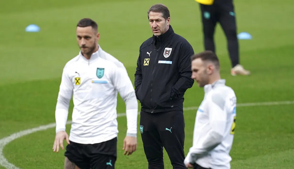 Pelatih Austria Franco Foda (tengah) melihat pemain Andreas Weimann dan Marko Arnautovic (kiri) saat sesi latihan jelang menghadapi Wales pada pertandingan kualifikasi Piala Dunia 2022 di Stadion Cardiff City, Wales, 23 Maret 2022. (Nick Potts/PA via AP)