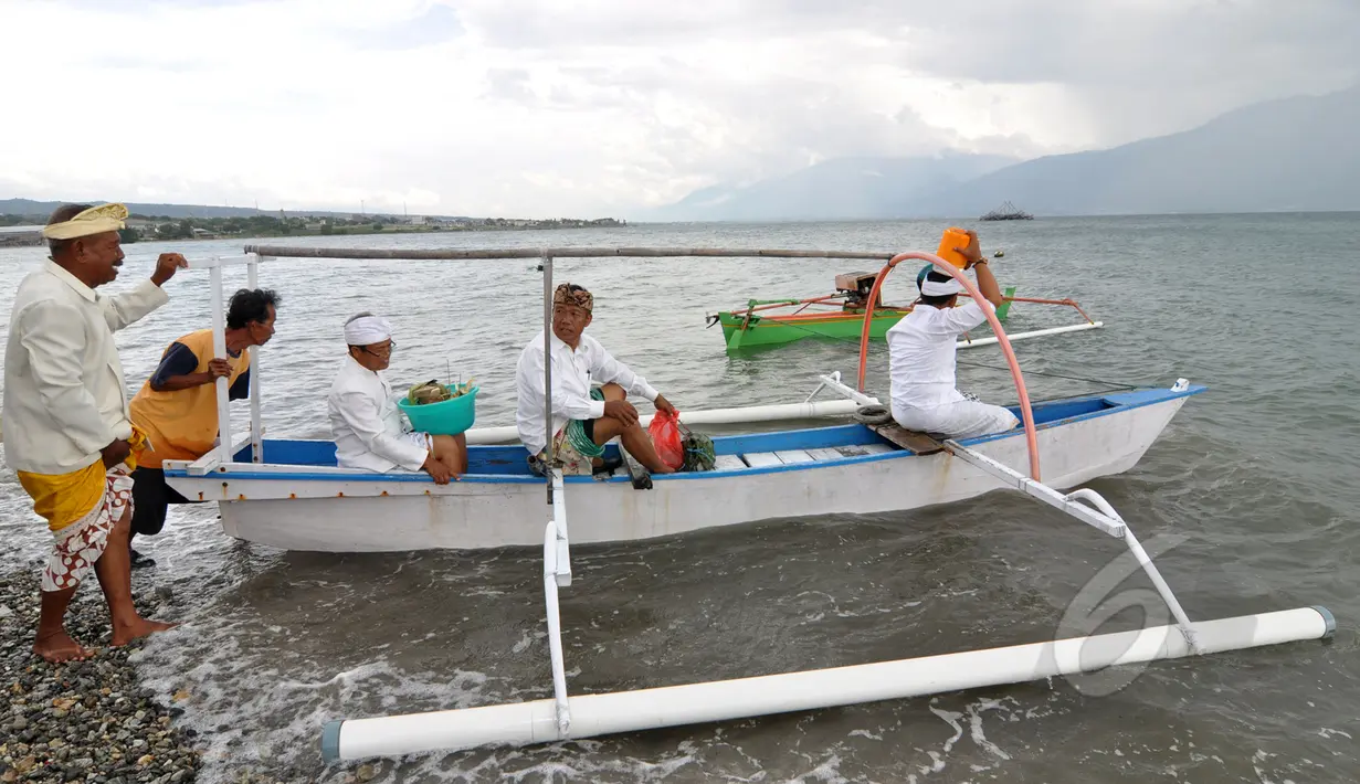 Sejumlah Umat Hindu membawa benda-benda sakral ke laut saat upacara Melasti menjelang Hari Raya Nyepi Tahun Saka 1937 pada Sabtu (21/3) mendatang  di pantai Dupa, Palu, Sulawesi  Tengah, Kamis (19/3/2015). (Liputan6.com/Dio Pratama)