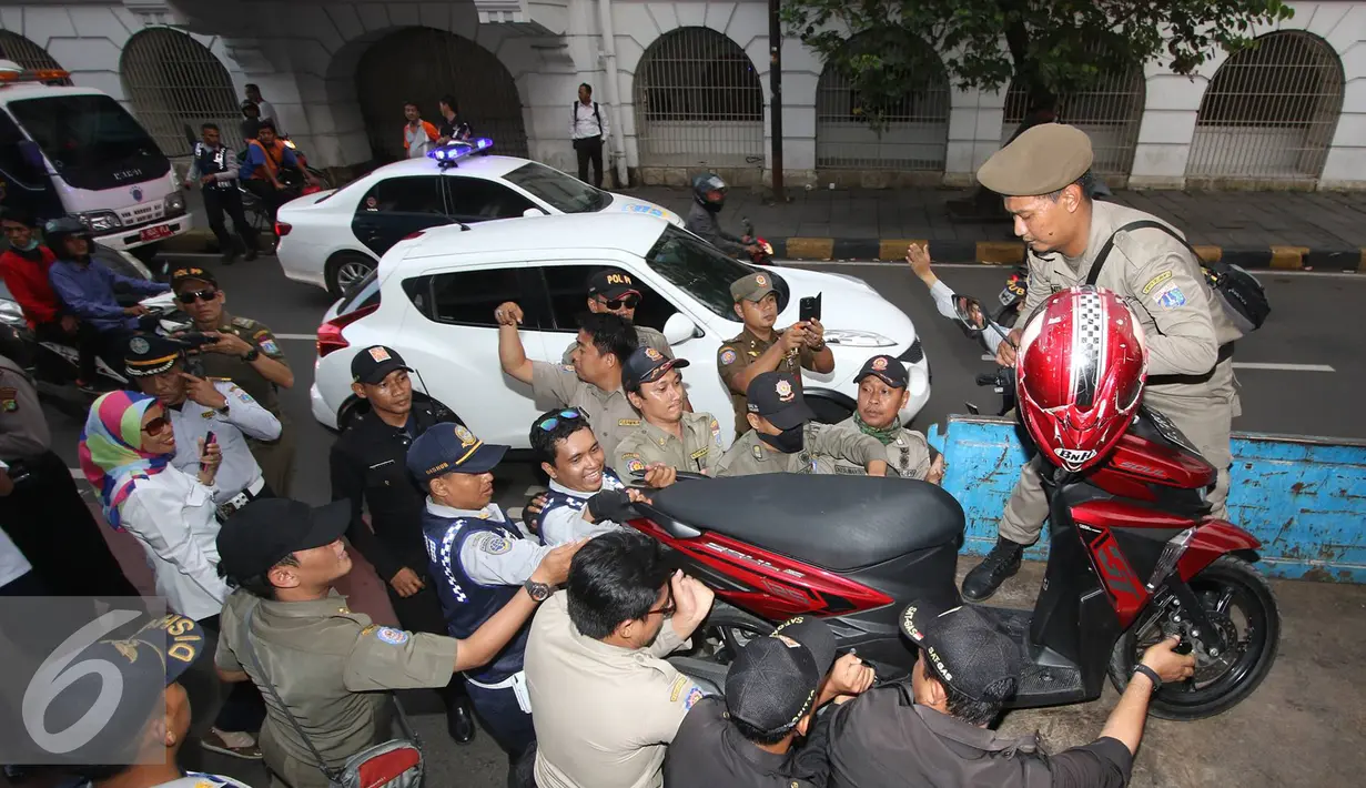 Petugas menertibkan sebuah motor di kawasan wisata Kota Tua, Jakarta, Rabu (24/8). Penertiban dilakukan guna membenahi PKL dan parkir liar yang kerap menimbulkan kesewrautan di lokasi tersebut. (Liputan6.com/Immanuel Antonius)