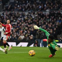 Gelandang Tottenham Hotspur asal Inggris James Maddison (kiri) melepaskan tembakan untuk mencetak gol pembuka melewati kiper Manchester United asal Kamerun Andre Onana (kanan) selama pertandingan sepak bola Liga Primer Inggris antara Tottenham Hotspur dan Manchester United di Stadion Tottenham Hotspur di London, pada 16 Februari 2025.Glyn KIRK / AFP