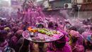 Umat Hindu dengan persembahan berjalan menuju mobil yang membawa patung dewa Krishna selama festival Holi di Kolkata, India, Minggu, 5 Maret 2023. Holi atau Festival Warna adalah festival awal musim semi yang dirayakan di India, Nepal, Bangladesh, dan negara-negara berikut yang memiliki penduduk beragama Hindu. (AP Photo/Bikas Das)