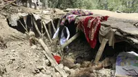 Seorang penduduk desa mengumpulkan barang-barangnya dari bawah puing-puing rumahnya yang hancur dalam gempa bumi di Distrik Spera, bagian barat daya Provinsi Khost, Afghanistan, 22 Juni 2022. Ini merupakan salah satu gempa paling mematikan di Afghanistan dalam beberapa dasawarsa. (AP Photo)