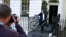 Seorang pria mengambil gambar Mantan Wali Kota London, Boris Johnson menggunakan sepeda saat akan meninggalkan rumahnya di London , Inggris, (21/6). (REUTERS / Peter Nicholls)